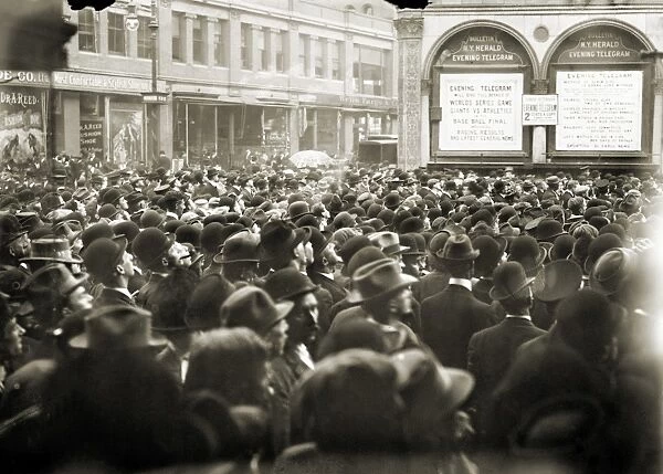 WORLD SERIES, 1911. A crowd gathered outside the New York Herald newspaper building in New York City receiving play-by-play information from a playograph during the 1911 World Series between the Philadelphia Athletics and the New York Giants, October 1911