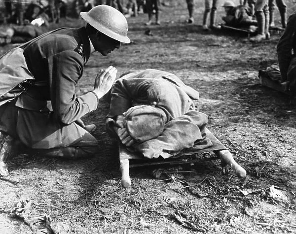 WORLD WAR I: PRIEST. A British priest saying a prayer over a dying German soldier