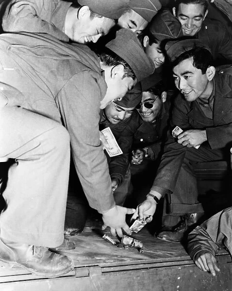 WORLD WAR II: DOMINOES. The 442nd Combat Team relaxes while playing a game of galloping