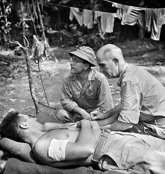 WORLD WAR II: NEW GUINEA. A wounded American soldier receiving a blood transfusion