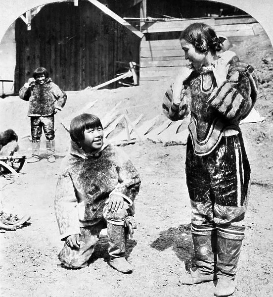 WORLDs FAIR: ESKIMOS. A woman dressed as an Eskimo standing next to a young Eskimo boy