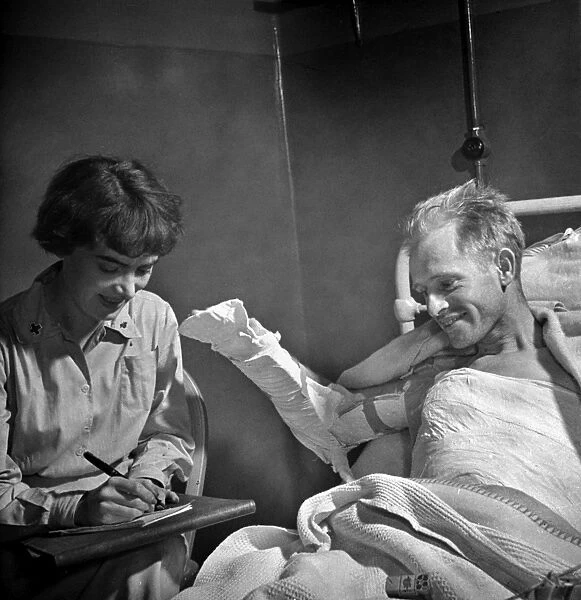 WOUNDED SOLDIER, 1942. A wounded American soldier being assisted by a Red Cross