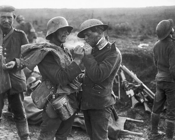 WWI: BRITISH & GERMAN SOLDIER. A German soldier lights the cigarette of a British