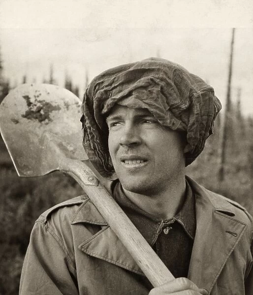 WWII: ALASKA, 1942. Private M. Swain wearing a mosquito net during the construction