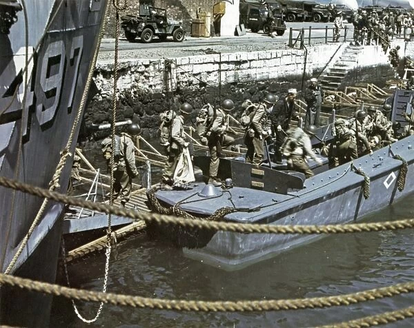 WWII: D-DAY, 1944. American troops boarding barges in a British port town, in preparation