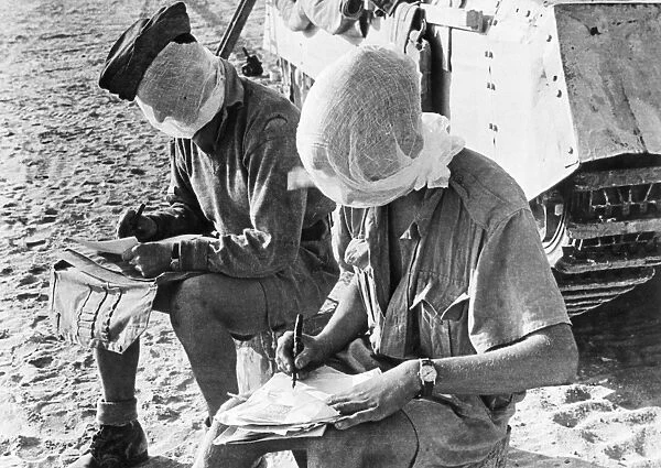 WWII: EGYPT, c1941. British troops wearing mosquito netting and writing letters