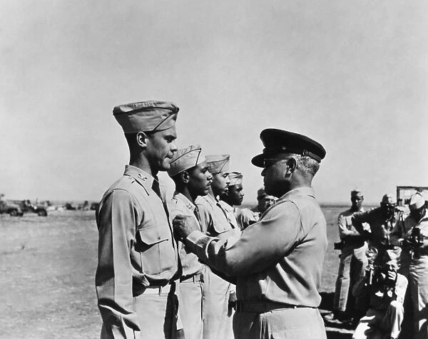 WWII: FLYING CROSS AWARDS. Brigadier General Benjamin Oliver Davis, Sr. pins the Distinguished Flying Cross on his son, Benjamin O. Davis, Jr. while Joseph Elsberry, Jack Holsclaw, Clarence Lester await their turn, in Italy, 1944