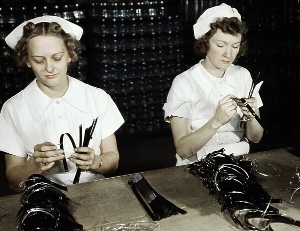 WWII: WORKERS, 1942. Navy wives Eva Herzberg and Elve Burnham assembling bands