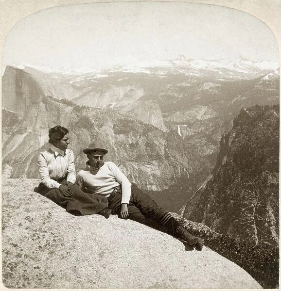YOSEMITE VALLEY, c1902. A couple seated on a rock at the top of the cliff in Yosemite National Park, California. Stereograph, c1902