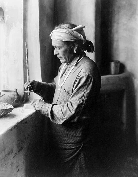 ZUNI BEAD WORKER, c1903. Zuni bead worker drilling holes in beads in his workshop