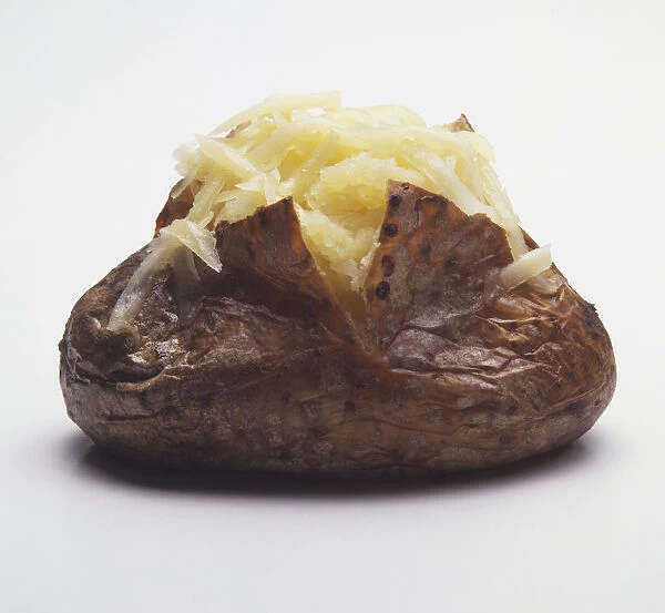 A baked potato topped with grated cheese