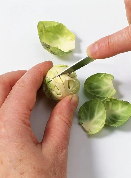 Brussels sprouts being cut using paring knife