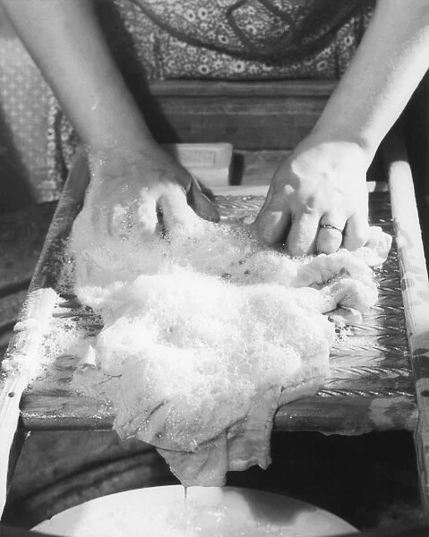 Close-up of woman washing clothes on washboard