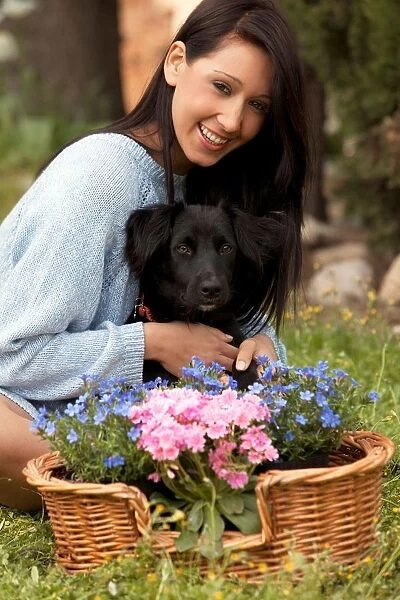 Girl with a Basket of Flowers While Embracing a Dog