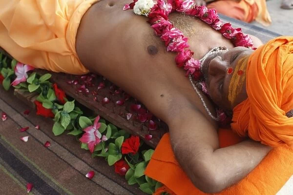Guru lying on a bed of nails in Pilot Baba camp at Kumbh Mela in Haridwar