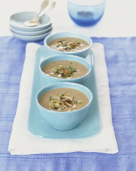 Mushroom and chestnut soup served in three blue bowls