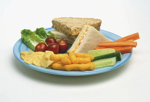 Two sandwiches, made with white and wholemeal bread, and carrots, cucumbers, salad, cherries and crisps, on a blue plate