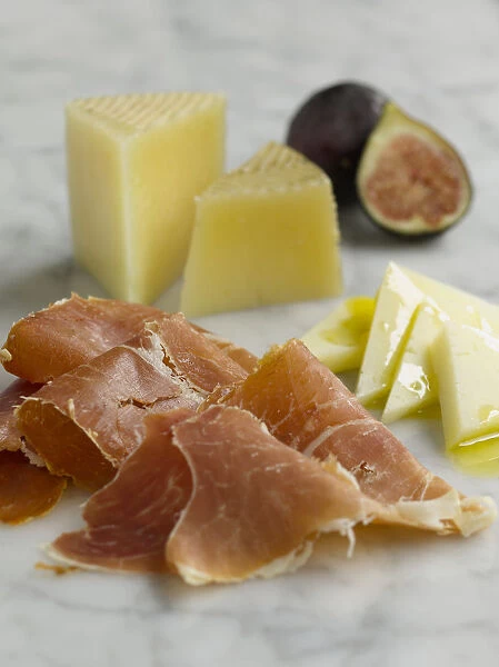 Slices of Manchego cheese, ham and figs, close-up
