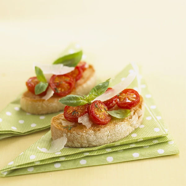 Tomato bruschetta with parmesan shavings and basil leaves, close-up