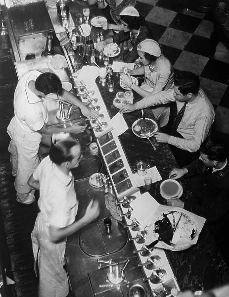 Fast Food. circa 1930: Americans eating lunch at a drug store soda fountain