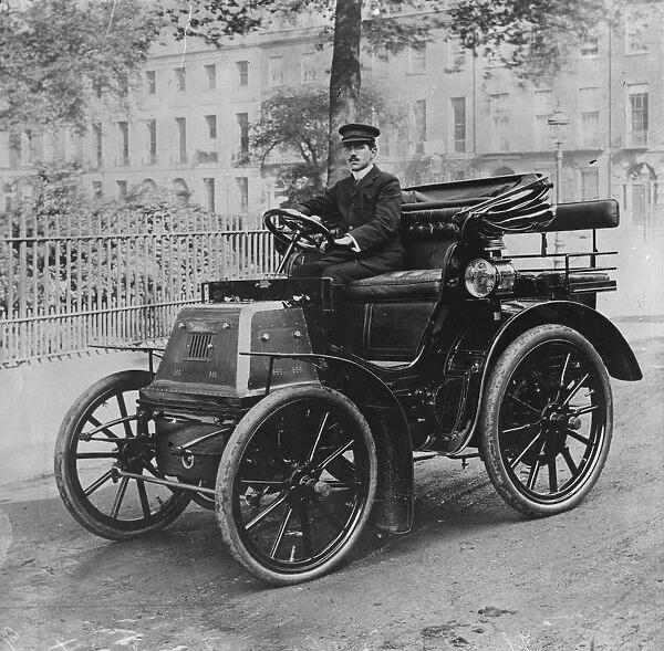 Kings Car. circa 1906: A chauffeur sitting at the wheel of the first car