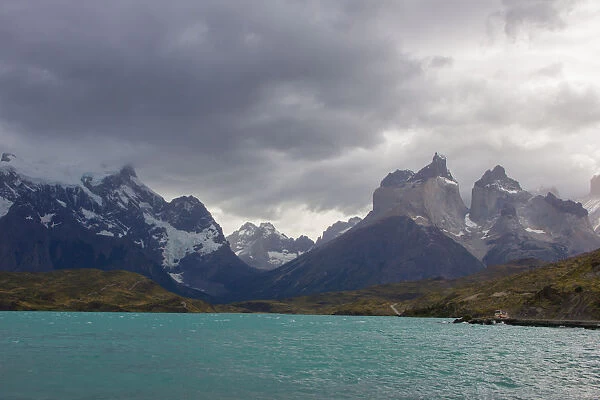 Looking across the cold waters of Lake Pehue to the snow-capped mountain peaks of the Torres del Paine National Park in the Magallanes Region of Patagonia, Southern Chile