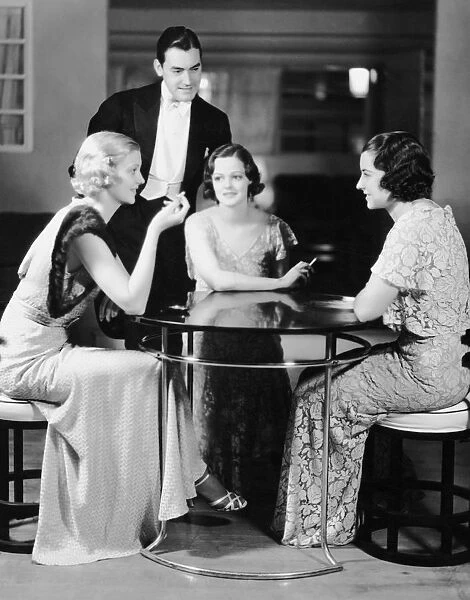 Man talking with three women in evening wear