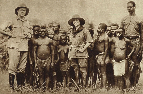 American explorer and his wife with a group of African Pygmies in the Belgian Congo (b  /  w photo)