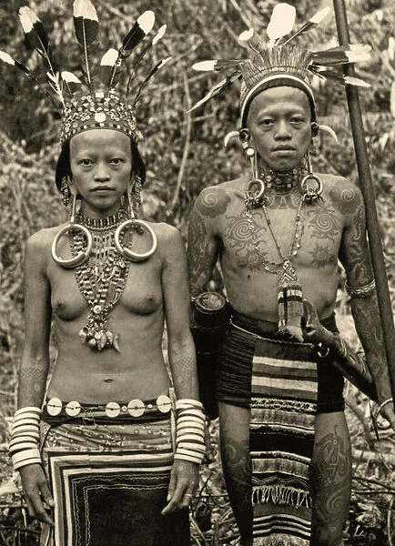 Dayak couple in traditional dress and tattoos, c. 1920 (b  /  w photo)