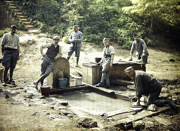 Six French soldiers with buckets and laundry at a fountain, Soissons, Aisne, France