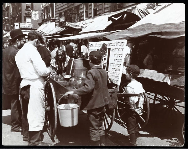View of children buying drinks from a peddler on Hester Street, New York