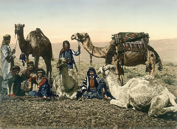 Western travellers dressed as Bedouins and their guides with their camels in the Jordan