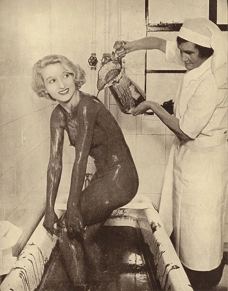 Woman having a mud bath treatment at a beauty salon (b  /  w photo)