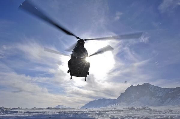 A CH-47 Chinook helicopter takes off from a remote landing zone