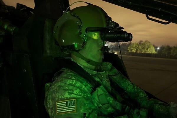 Pilot equipped with night vision goggles in the cockpit of an Apache helicopter