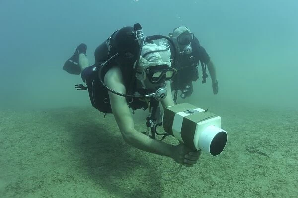U. S. Navy diver uses an AN  /  PQS 2A handheld sonar device while training in the Red Sea