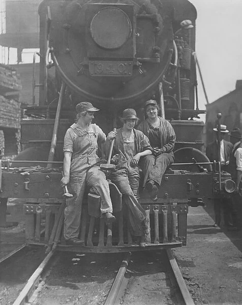 Women laborers seated on front of engine at Bush Terminal railroad yard, 1918