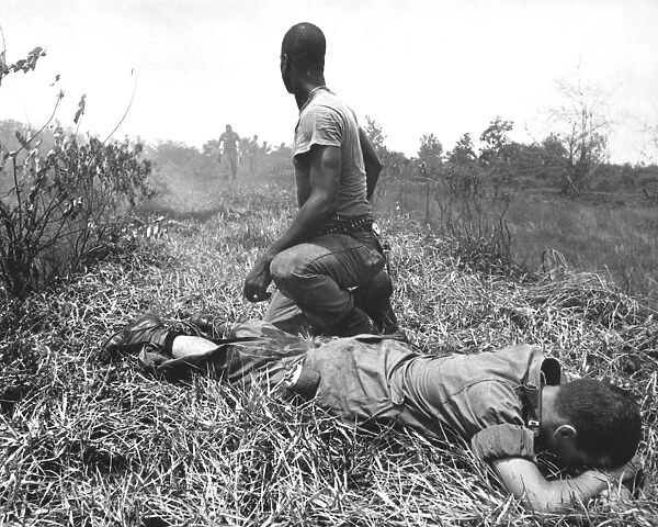 A young American lieutenant is treated by a medic in Vietnam, 1966