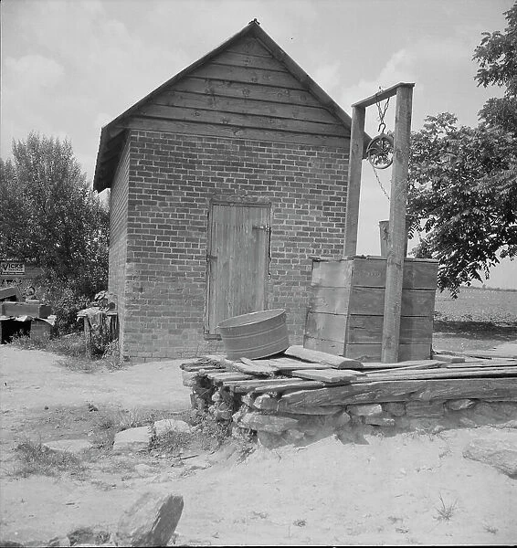 Well and old plantation smokehouse, Chesnee, South Carolina, 1937. Creator: Dorothea Lange