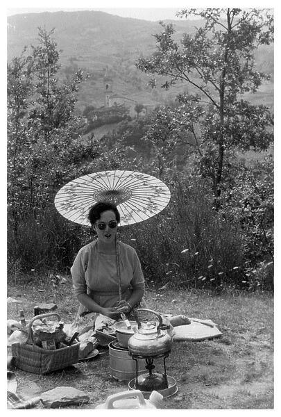 Woman under a parasol having a picnic, c1950-1969(?)