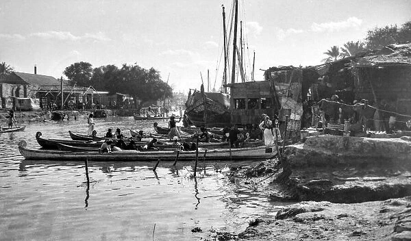 Glass negative world war one photograph in Iraq (Mesopotamia), the riverfront of Amara, Ashar Creek with boats, people and cargo; Amara, Iraq