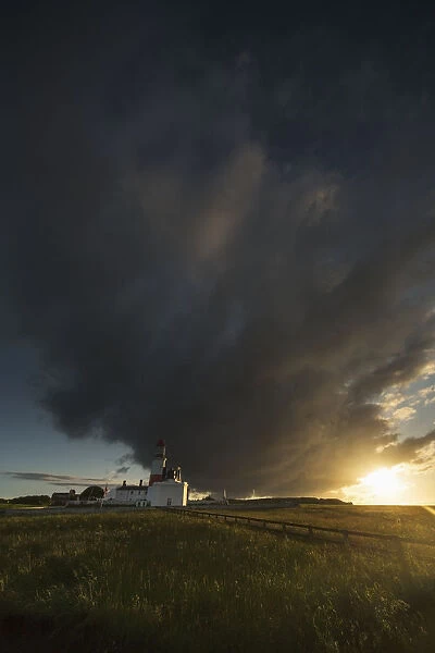 Storm cloud formation over a lighthouse at sunset; South shields tyne and wear england