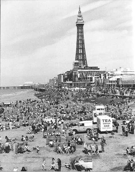 Blackpool Tower with people sitting on Blackpool Beach