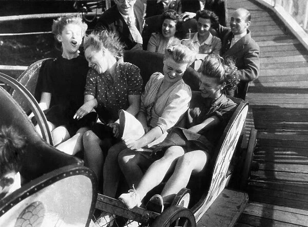 Four friends enjoy a fairground ride during the August Bank Holidays. August 1946 P000019