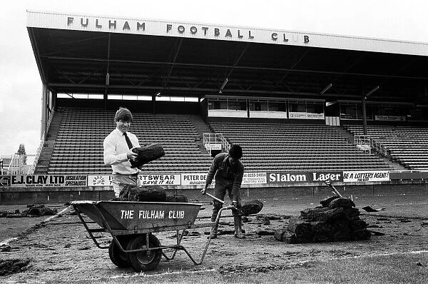 Fulham manager Malcolm Macdonald with a roll of turf at Craven Cottage as the pitch is