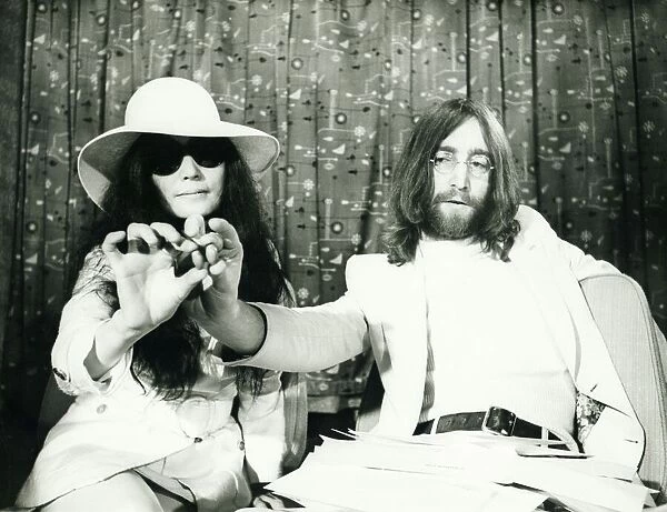John Lennon and Yoko Ono at London airport presenting acorns they intend sending to heads
