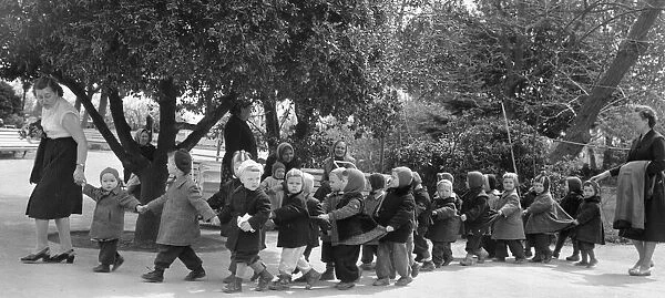 Kindergarten teachers lead their young charges though a Yalta park in the USSR