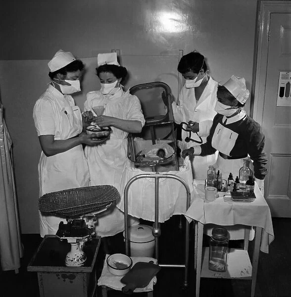 Midwives help delivery a two pound baby which was placed in an incubator. May 1953 D2623