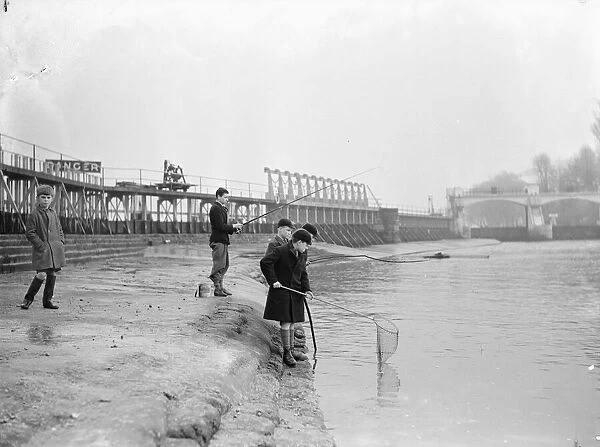 Schoolboys fishing at Teddington Weir during the winter drought of 1933