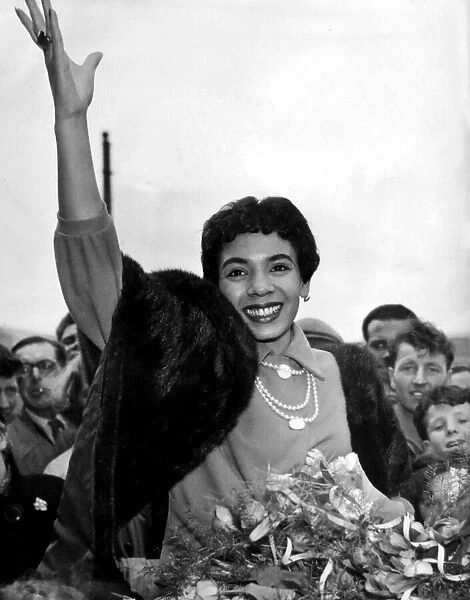 Shirley Bassey waves to the crowd who turned out to welcome her as she arrived back in